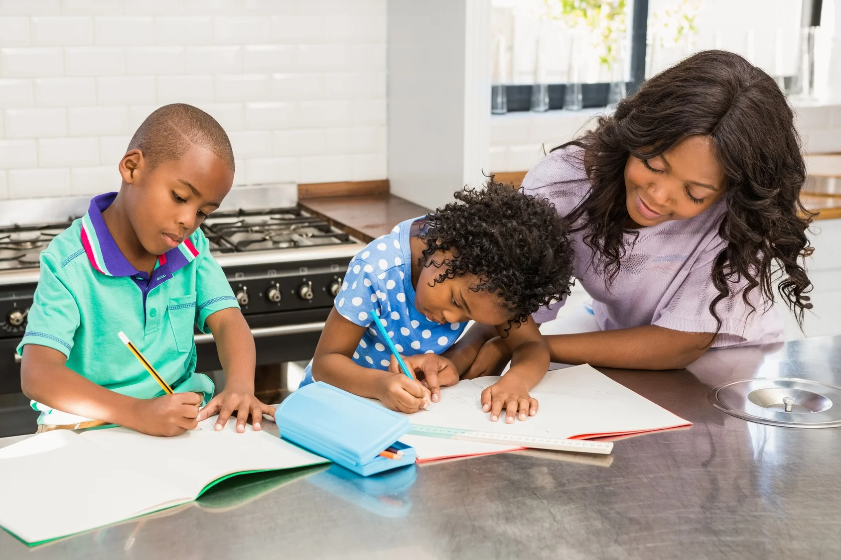 A volunteer helping two children with their writing