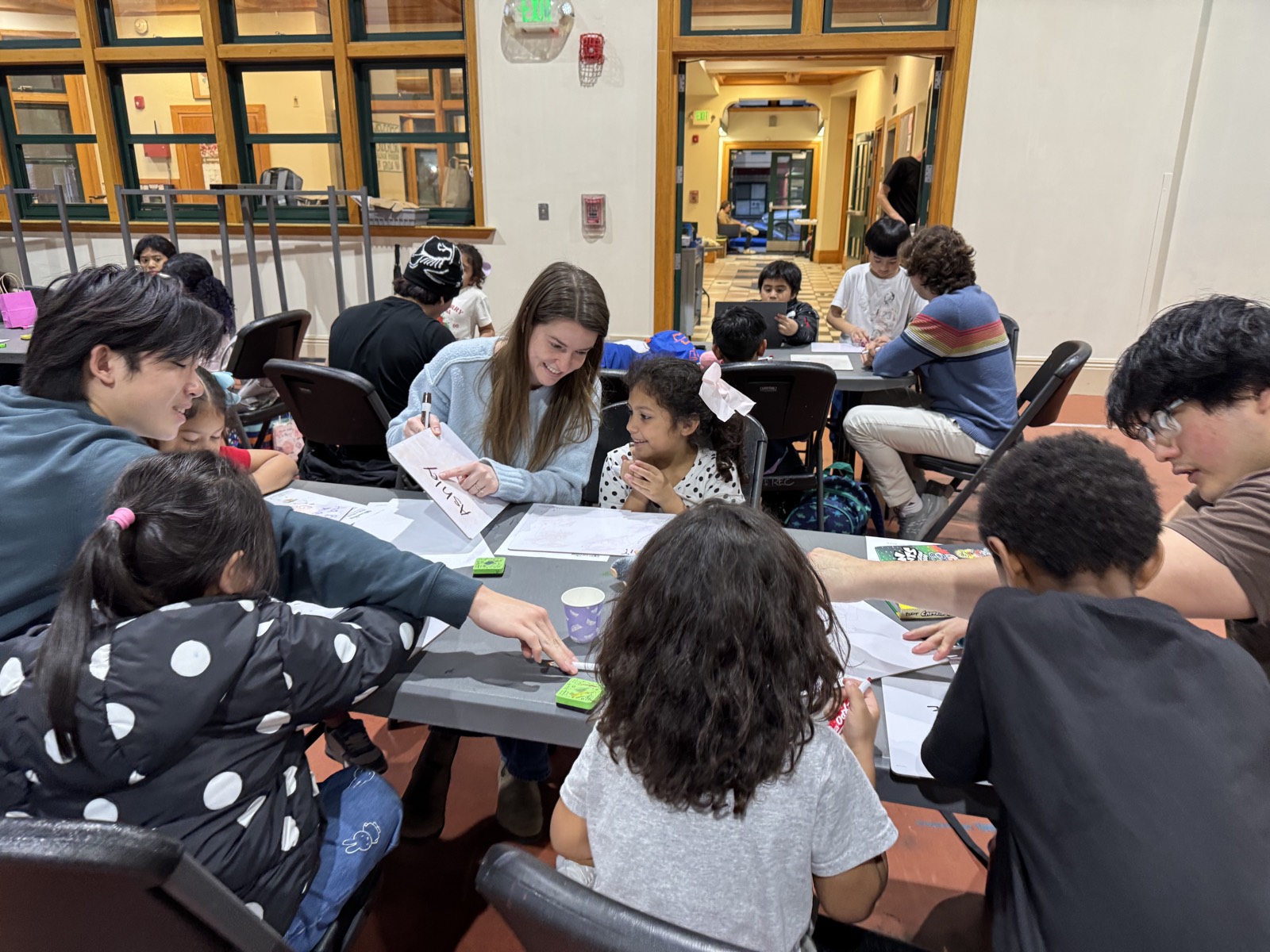 A volunteer reading with a group of children around a table