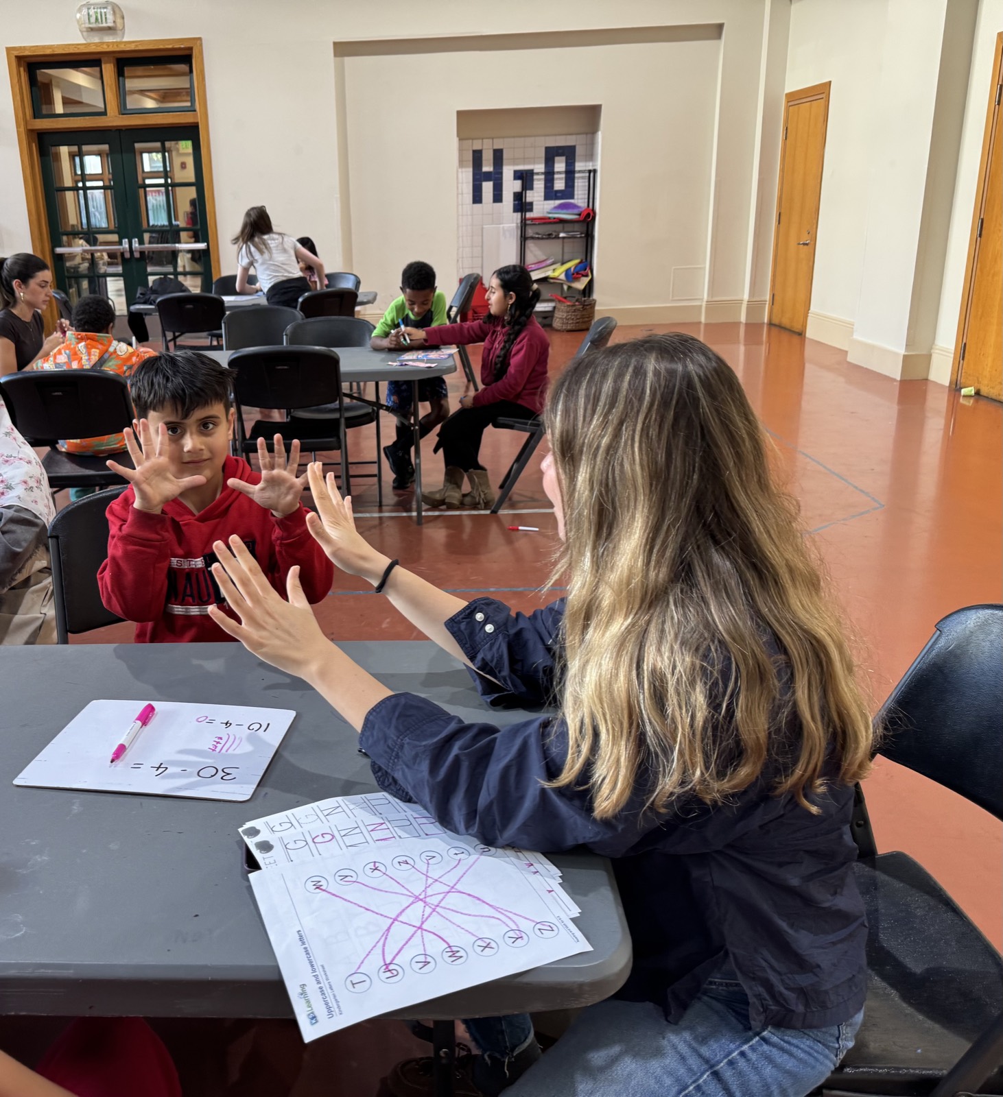 A volunteer and a child counting together on their fingers
