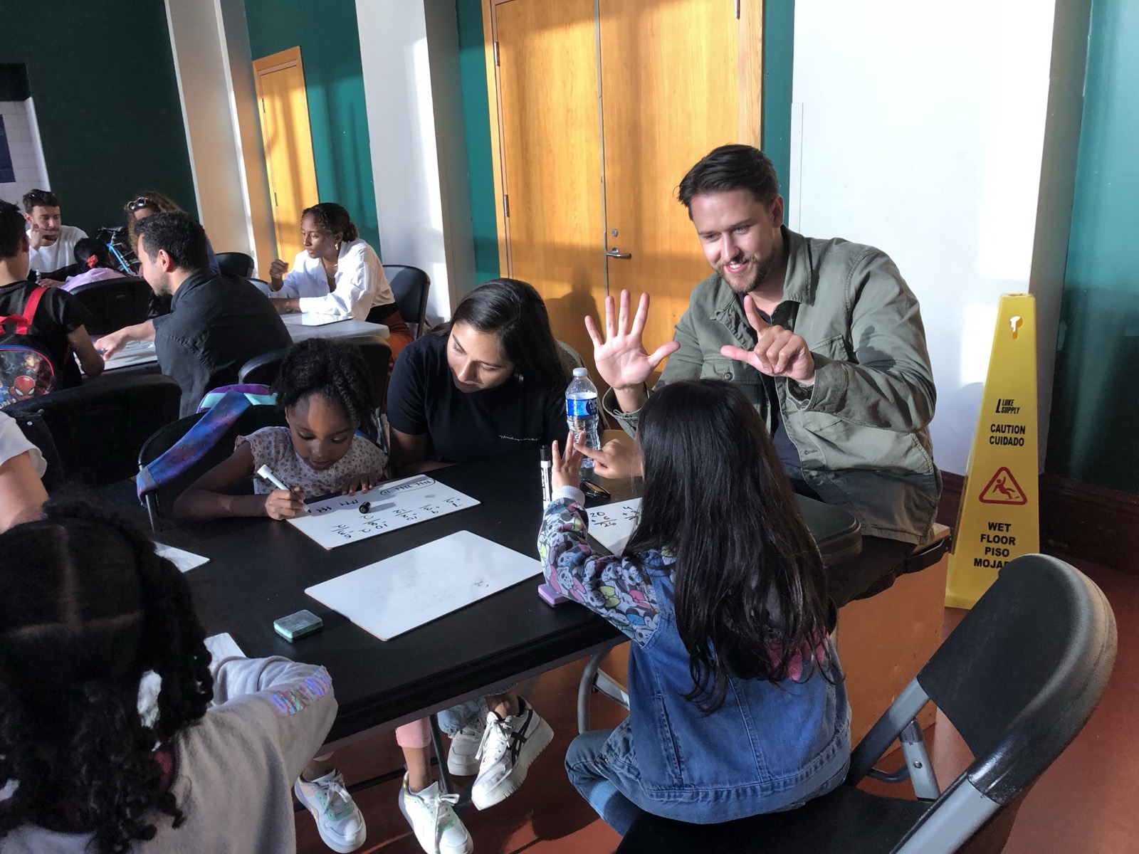 A volunteer counting on both hands with a child during a math exercise