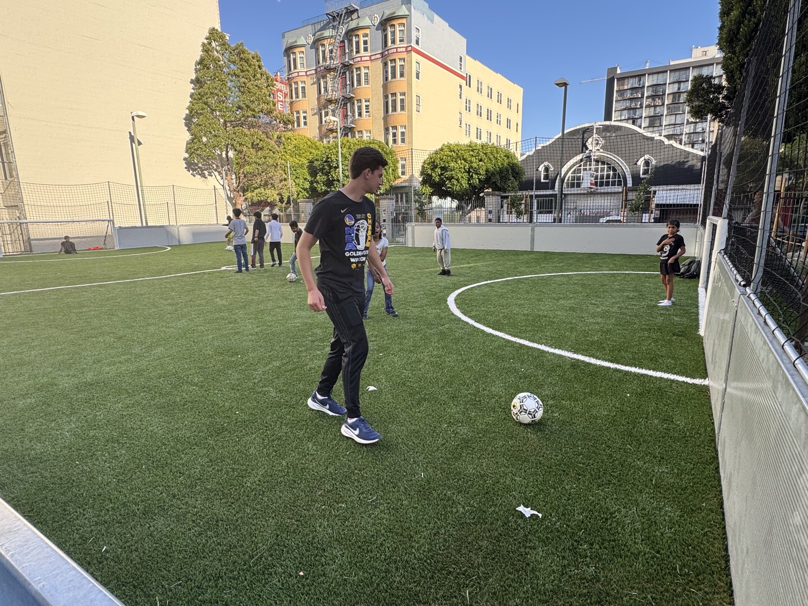 A child dribbling a soccer ball on the outdoor pitch