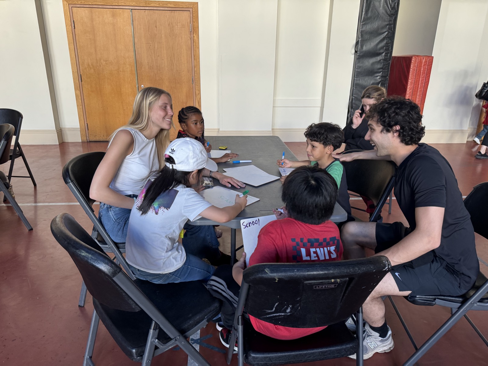 A group of volunteers and children gathered around a table to work together